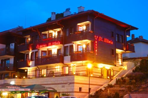a large building with lights on it at night at Family Hotel Saint Nikola and Free parking in Nesebar