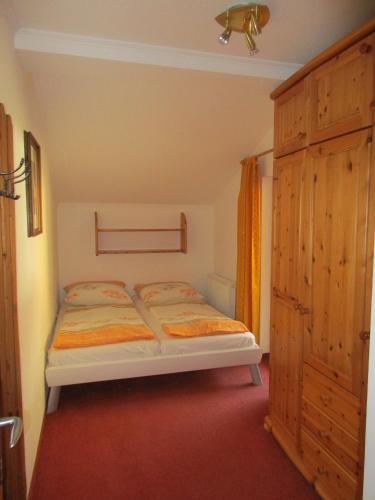 a small bedroom with a bed and a wooden cabinet at Moisesgut in Bad Hofgastein