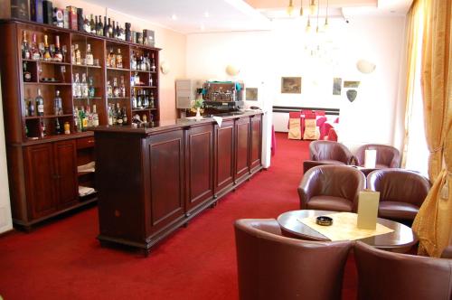 a room with a bar with brown leather chairs at Hotel Miraj - Restaurant & Sauna & Biliard in Poiana Brasov