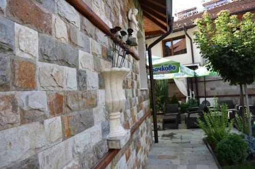 a stone wall with a vase on the side of a building at Complex Oazis in Etropole