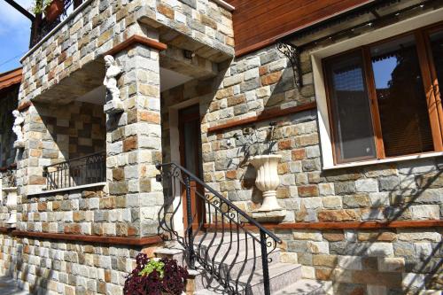 a stone house with a staircase and a window at Complex Oazis in Etropole