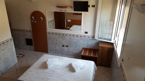 a small room with a bed and a mirror at Motel Villaggio in Imola