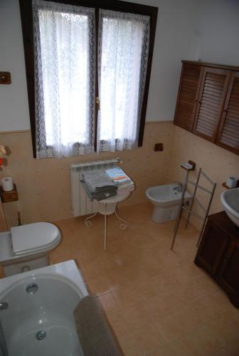 Pieve di TecoにあるAppartamento 26のバスルーム(洗面台2台、バスタブ、トイレ付)