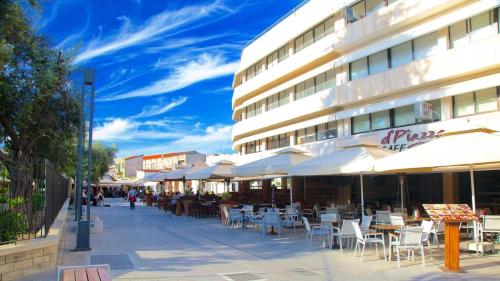 a street with tables and chairs and a building at Artemis Boutique Apartment 1 in Limassol