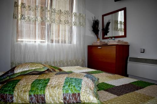 a bedroom with a bed and a dresser and a window at Complex Oazis in Etropole