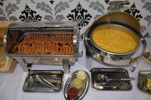 a stove with a pot of food and a pot of beans at Hotel Roztocze in Zwierzyniec