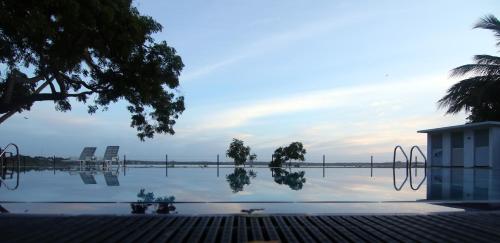 Blick auf einen Pool mit Stühlen im Wasser in der Unterkunft Jade Green Hambantota in Hambantota