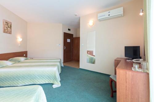 a hotel room with two beds and a television at Hotel L&B- Free parking in Sunny Beach
