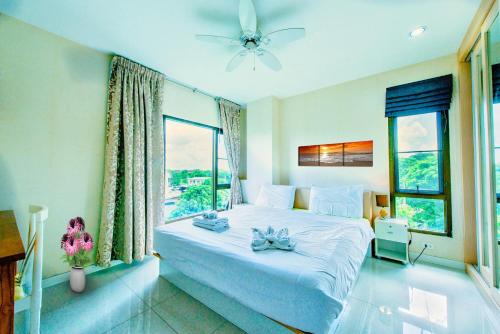 a bedroom with a large white bed with a window at Tree Boutique Residence - Quiet Oasis - Stunning View, Pool & Gym in Chiang Mai