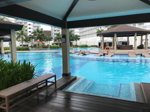 a large swimming pool with chairs and a building at BEST Q CONDO w/ Great View in Manila