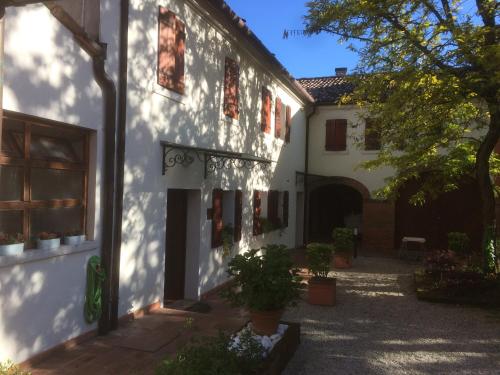 a white building with red windows and a courtyard at Locanda Stella D'oro in Quinto di Treviso