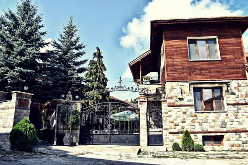a stone house with a gate in front of it at Complex Oazis in Etropole