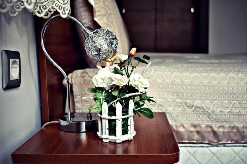 a lamp and a vase with flowers on a table at Complex Oazis in Etropole