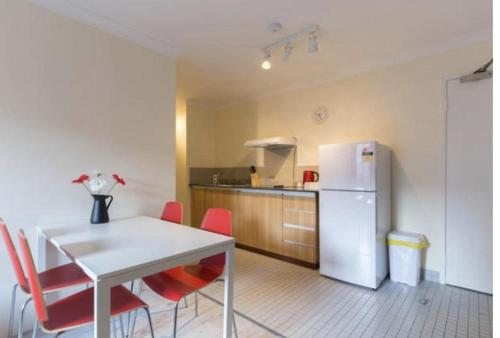 a kitchen with a white table and a white refrigerator at Wheeler Apartments Perth in Perth