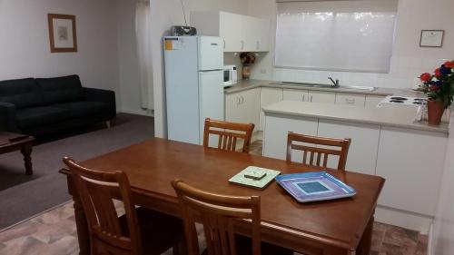 una cucina con tavolo e tablet di About Town Cottages a Broken Hill