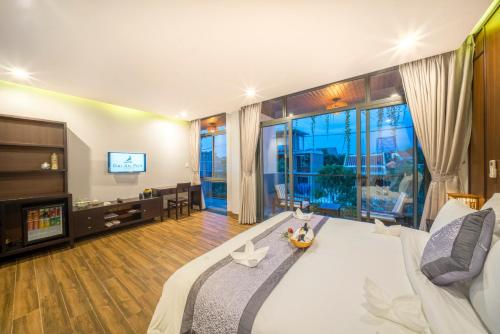 a living room with a couch and a tv at Dai An Phu Villa in Hoi An