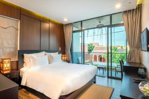 a hotel room with a bed and a balcony at Dai An Phu Villa in Hoi An