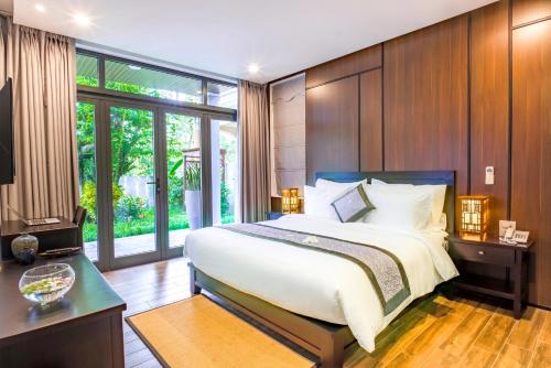 een slaapkamer met een groot bed en een groot raam bij Dai An Phu Villa in Hội An
