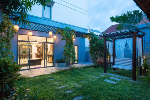 a blue house with a bench in the yard at Dai An Phu Villa in Hoi An