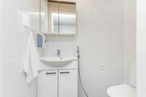 a white bathroom with a sink and a toilet at Holiday Club Himos Superior Apartments in Jämsä
