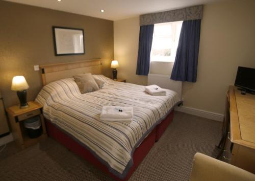 een hotelkamer met een bed met handdoeken erop bij The Plough Inn in Little Dewchurch