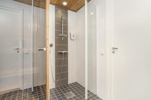 y baño con ducha y puerta de cristal. en Holiday Club Himos Superior Apartments, en Jämsä