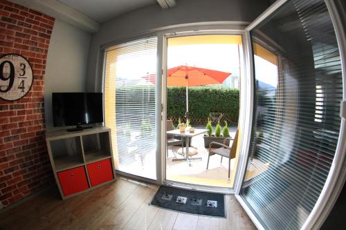 a room with a patio with a table and an umbrella at La Ferme des Fées in Bévilard