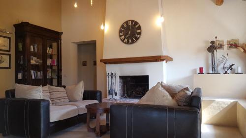 a living room with a couch and a clock on the wall at Tenuta San Marcello in San Marcello
