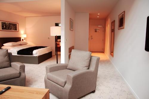 a hotel room with a bed and a couch and chair at Great Polonia The Granary La Suite Hotel in Wrocław
