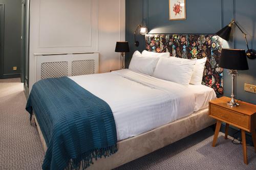 斯蒂夫尼奇Hotel Cromwell Stevenage的卧室里有一张大床，墙壁是蓝色的