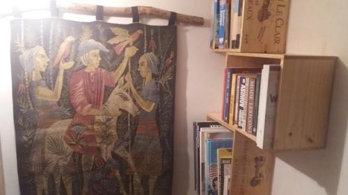 a tapestry hanging on a wall next to a book shelf at Golden Lion in Bouillon