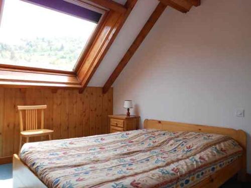 a bedroom with a bed and a large window at Résidence du Chajoux in La Bresse