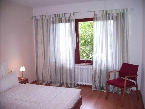 una camera con un letto e una sedia e una finestra di Ferienwohnung Andrea a Eberbach
