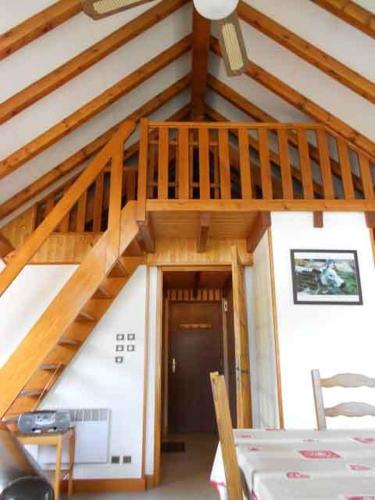 une chambre avec un escalier en bois dans une maison dans l'établissement Résidence du Chajoux, à La Bresse