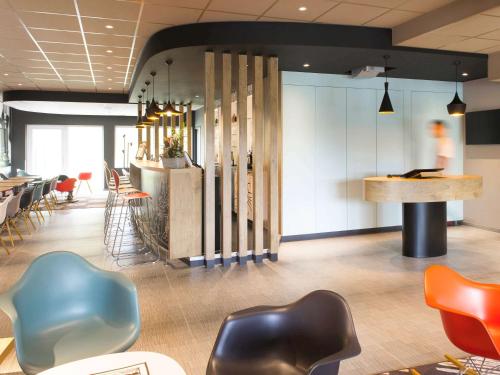 
a kitchen with a table and chairs in it at Ibis Wavre Brussels East in Wavre
