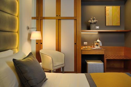 1 dormitorio con cama, escritorio y silla en Hotel Concord, en Riccione
