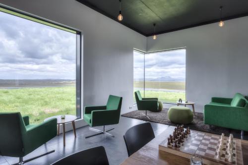 a living room with a chessboard and green chairs at Hótel Laxá in Myvatn