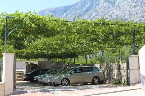 two cars parked in a parking lot with mountains in the background at Apartments Sveti Anton in Orebić
