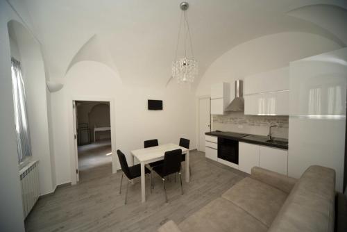 - un salon blanc avec une table et un canapé dans l'établissement Relais Virginia Home, à Sanremo