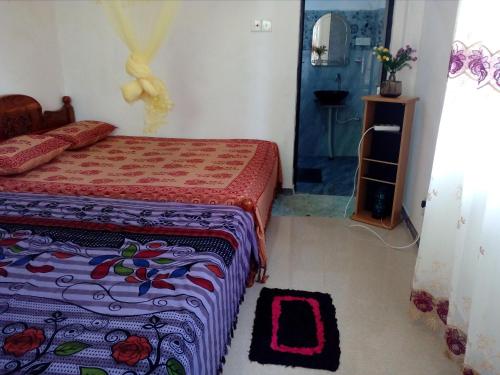 1 dormitorio con 1 cama y 1 habitación con espejo en House Of Esanya, en Negombo