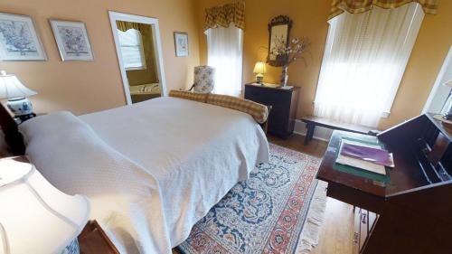 a bedroom with a white bed and a desk and a table sidx sidx sidx at Hanna House Bed & Breakfast in New Bern