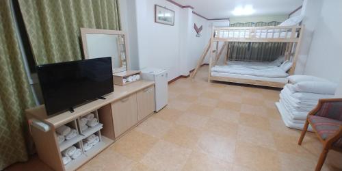 a living room with a television and a bunk bed at The Red House in Sokcho