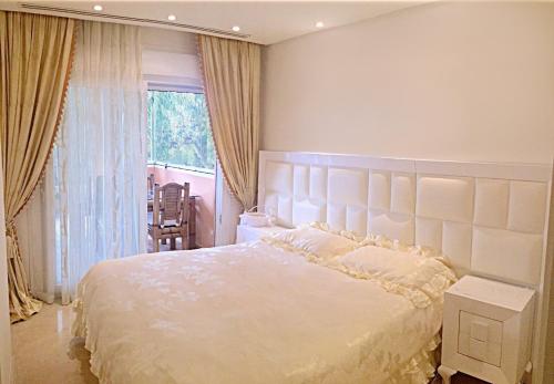 Un dormitorio con una gran cama blanca y una ventana en Luxury Residence Puerto Banus, en Marbella