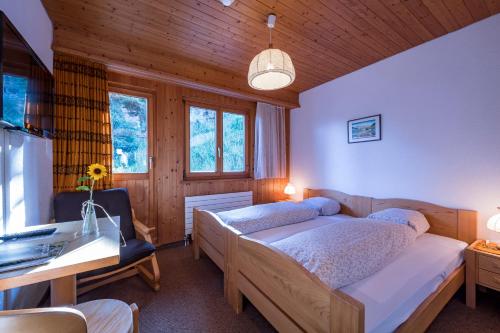 a bedroom with a bed and a desk in a room at Berghotel Sellamatt in Alt Sankt Johann