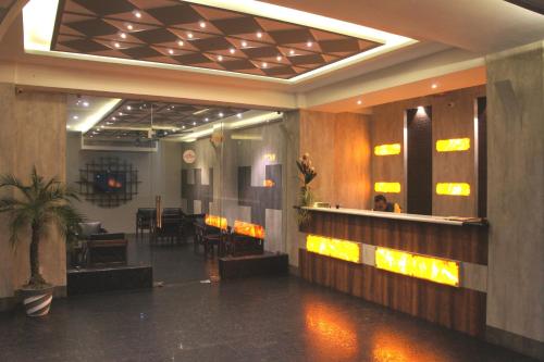 a lobby with a table and chairs in a building at The Loft Hotel, Siliguri in Siliguri