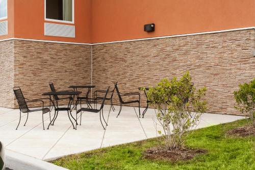 a patio with tables and chairs against a brick wall at Days Inn by Wyndham Watertown Fort Drum in Evans Mills