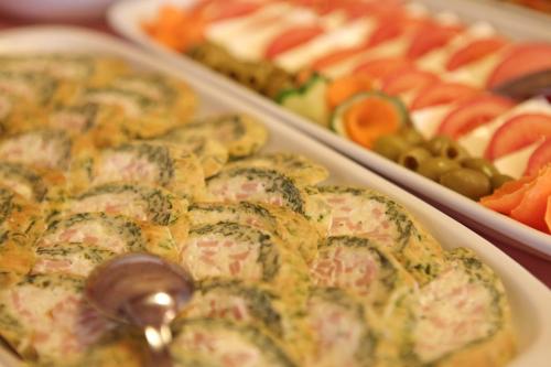 a tray of food with vegetables and other foods at Hotel Novella Uno in Novi Banovci
