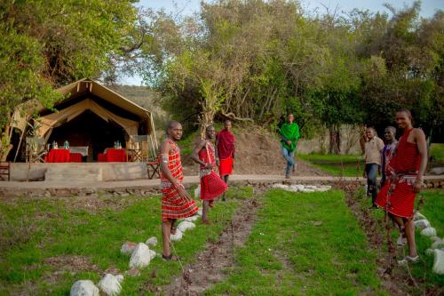 a group of people walking in front of a tent at Oldarpoi Wageni Camps in Keekorok