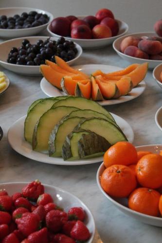 a table topped with plates of fruits and vegetables at Hôtel de la Cathédrale Metz in Metz