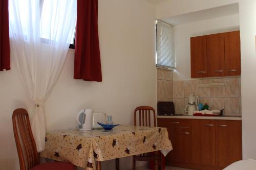 a kitchen with a table and chairs and a kitchen with a table and a table at Apartments Sveti Anton in Orebić